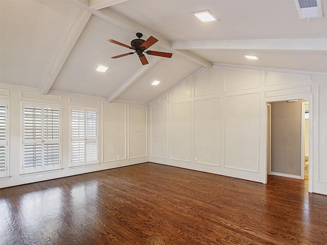 unfurnished room featuring lofted ceiling with beams, dark wood-style floors, a ceiling fan, and a decorative wall