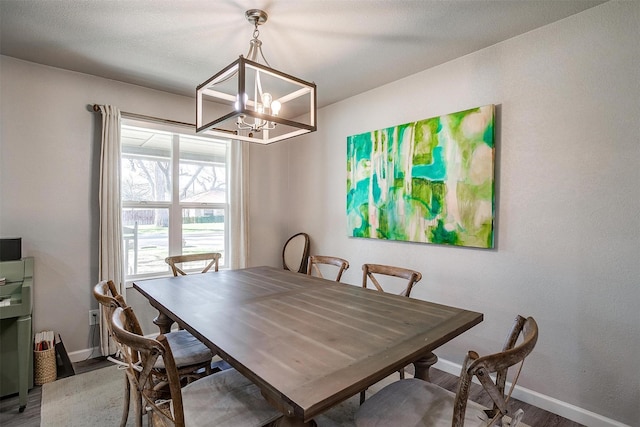 dining room featuring baseboards, wood finished floors, and a chandelier