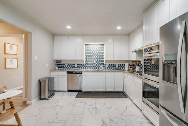 kitchen featuring a sink, white cabinets, marble finish floor, and stainless steel appliances