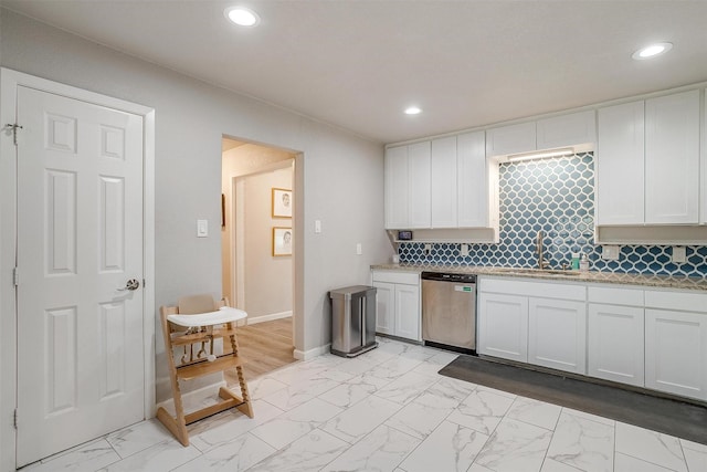 kitchen featuring marble finish floor, a sink, stainless steel dishwasher, white cabinetry, and recessed lighting