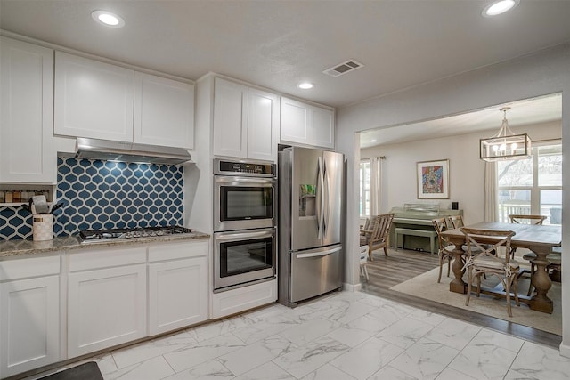 kitchen featuring visible vents, marble finish floor, under cabinet range hood, white cabinetry, and appliances with stainless steel finishes