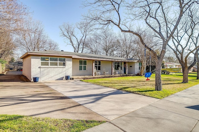 view of front of house with driveway, brick siding, and a front lawn