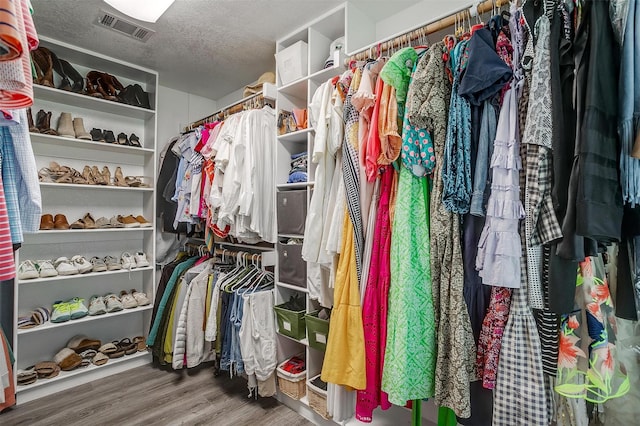 walk in closet with visible vents and wood finished floors