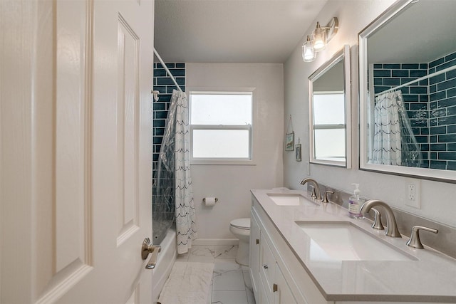 full bathroom with double vanity, shower / bath combo with shower curtain, marble finish floor, and a sink