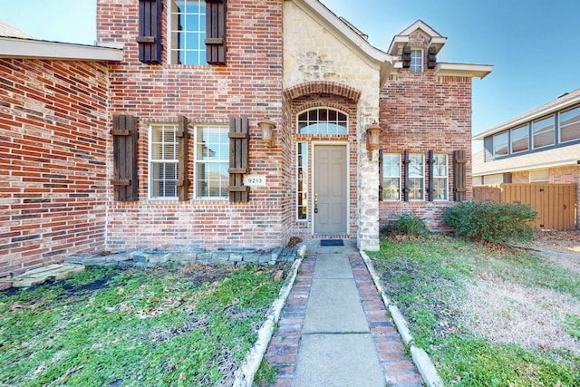 property entrance with brick siding and stone siding