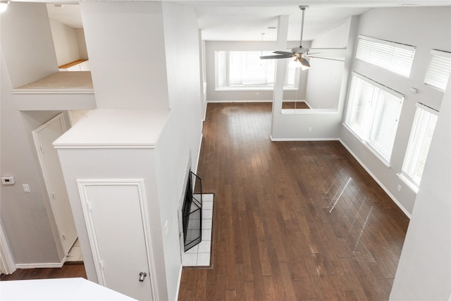 hallway featuring dark wood-type flooring and baseboards