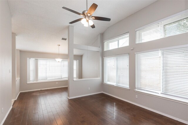 unfurnished room featuring baseboards, lofted ceiling, dark wood finished floors, and a ceiling fan