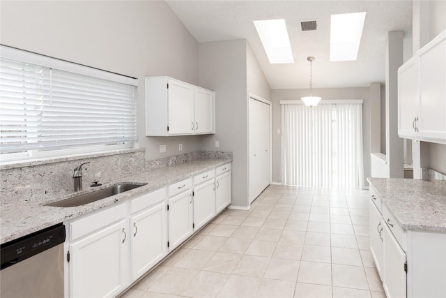 kitchen with visible vents, white cabinetry, a sink, stainless steel dishwasher, and lofted ceiling with skylight