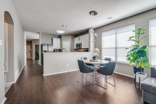 2212 River Birch Ln, Rockwall, TX 75032 - dining space with dark wood-style flooring, baseboards, healthy amount of natural light, and arched walkways