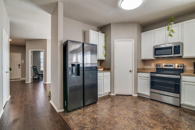 kitchen with light countertops, white cabinets, baseboards, and stainless steel appliances