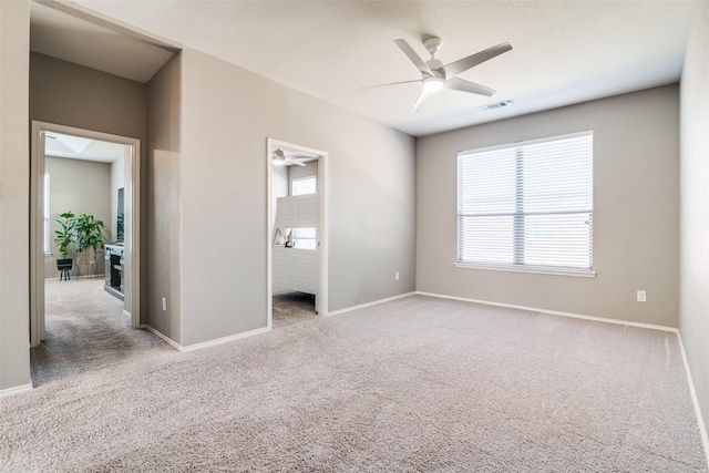 unfurnished bedroom with a ceiling fan, carpet flooring, baseboards, and visible vents