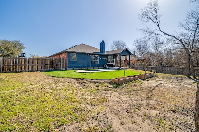 exterior space with a vegetable garden, a lawn, a chimney, and a fenced backyard