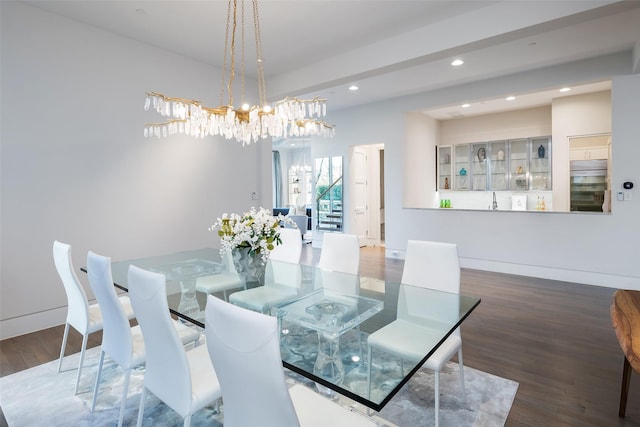 dining space with an inviting chandelier, recessed lighting, wood finished floors, and baseboards