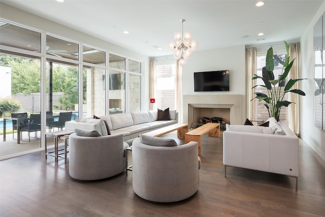 living area featuring a chandelier, recessed lighting, a fireplace, and dark wood-style flooring