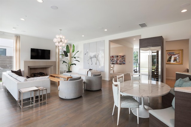 dining space featuring visible vents, recessed lighting, a fireplace, an inviting chandelier, and dark wood-style flooring