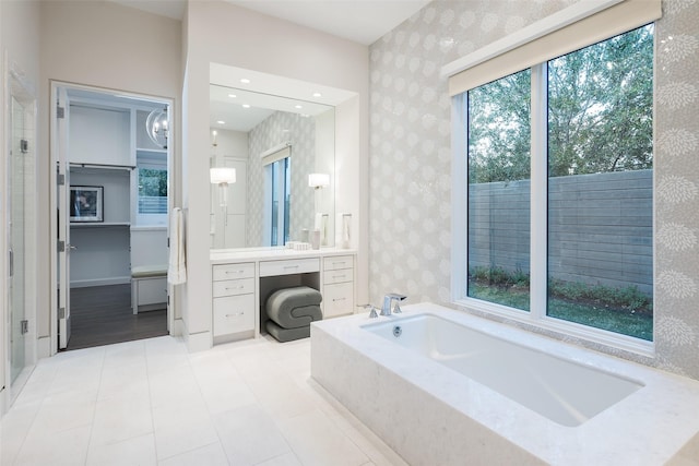 full bath with tile patterned flooring, a bath, vanity, and wallpapered walls