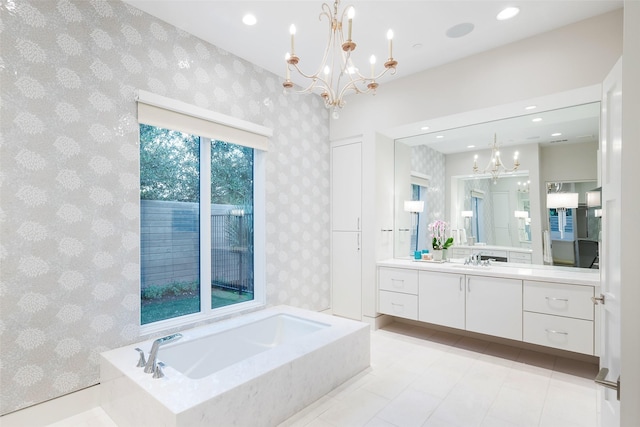 bathroom with a garden tub, an inviting chandelier, vanity, and wallpapered walls