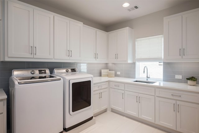 laundry room with visible vents, recessed lighting, cabinet space, a sink, and washer and dryer