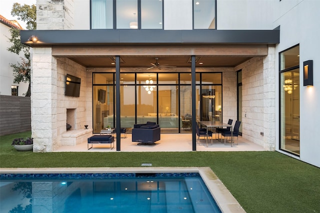 back of house featuring a patio, concrete block siding, fence, a yard, and an outdoor pool