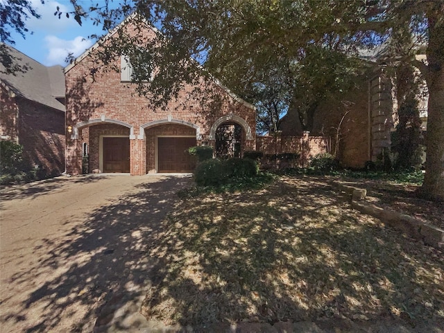 view of front of house featuring a garage, brick siding, and driveway