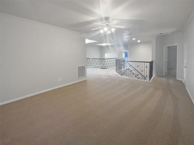 unfurnished room featuring ceiling fan, baseboards, visible vents, and light carpet