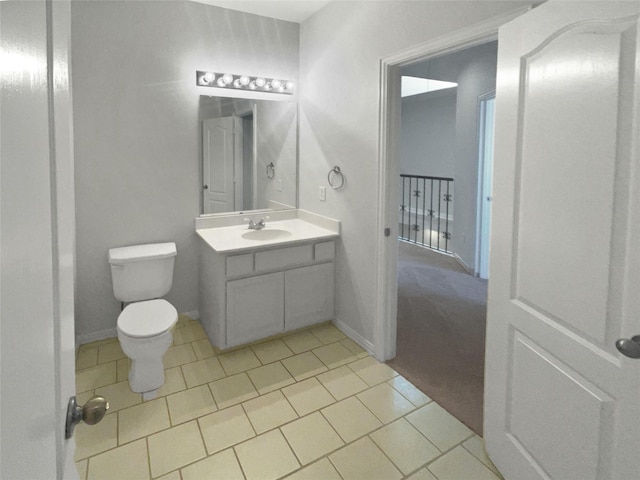 bathroom featuring baseboards, toilet, vanity, and tile patterned flooring