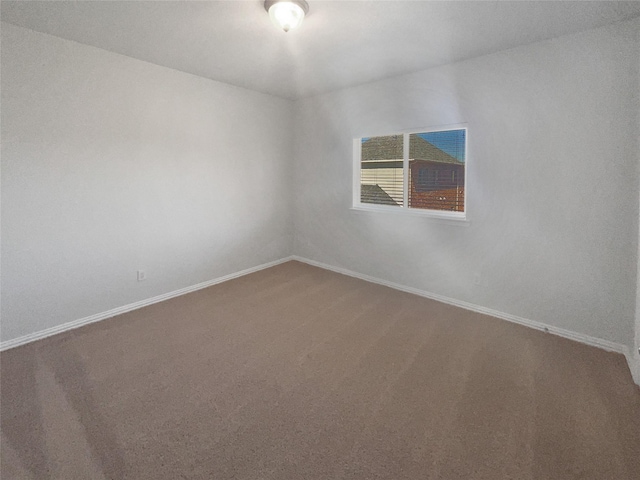 carpeted empty room with baseboards