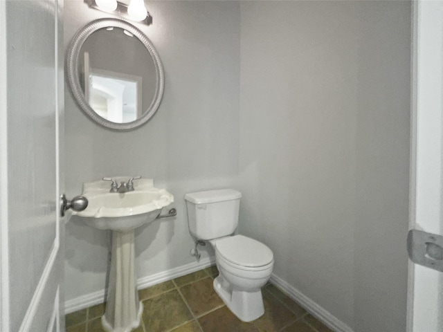 bathroom with tile patterned floors, toilet, and baseboards