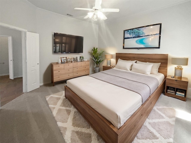 bedroom with visible vents, light carpet, baseboards, and ceiling fan