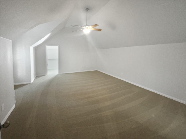 additional living space featuring baseboards, ceiling fan, and vaulted ceiling