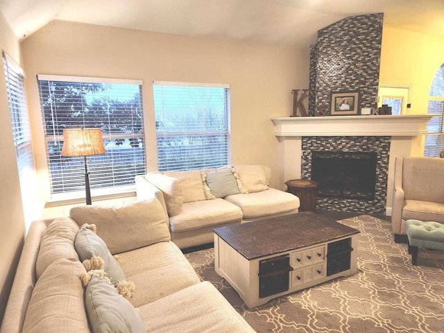 living room featuring vaulted ceiling and a tile fireplace