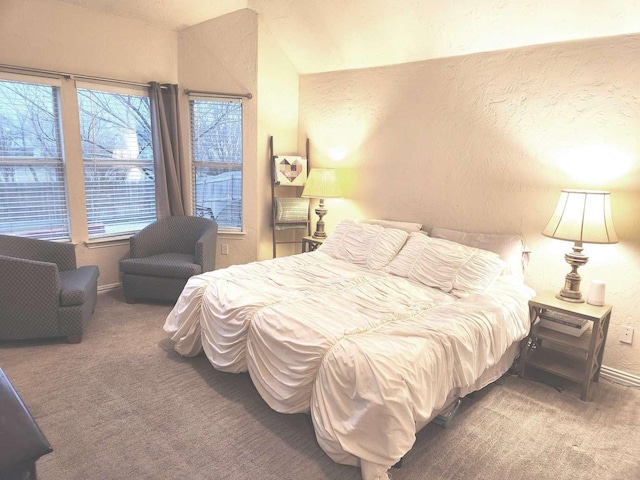 carpeted bedroom with a textured wall and baseboards