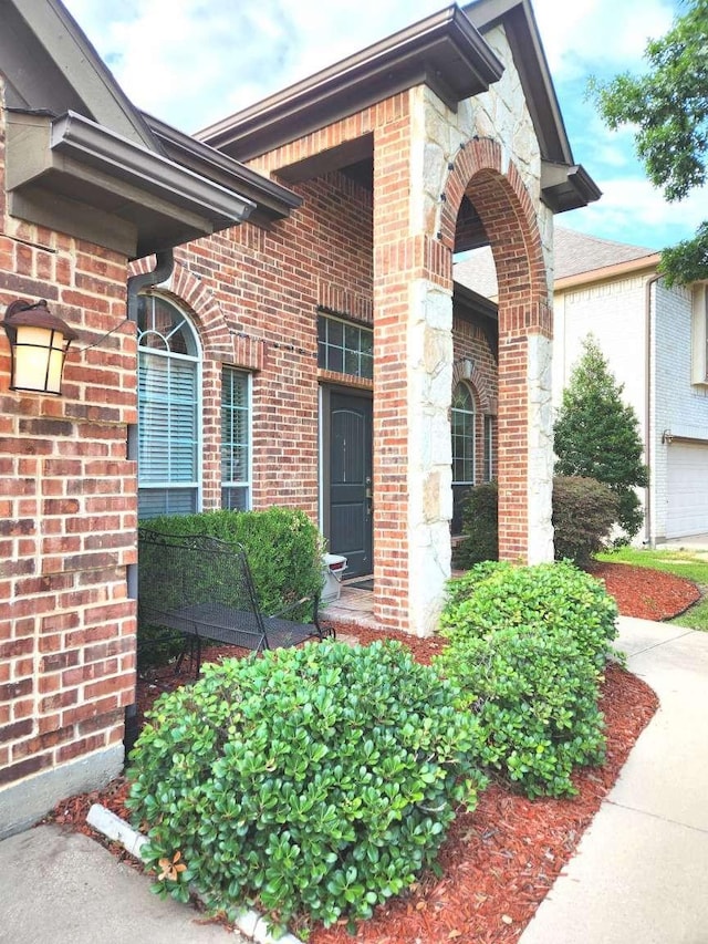 doorway to property featuring brick siding