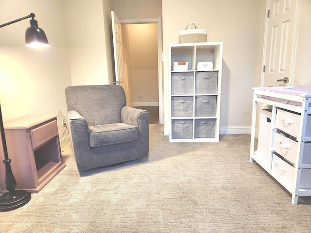 living area featuring carpet flooring and baseboards