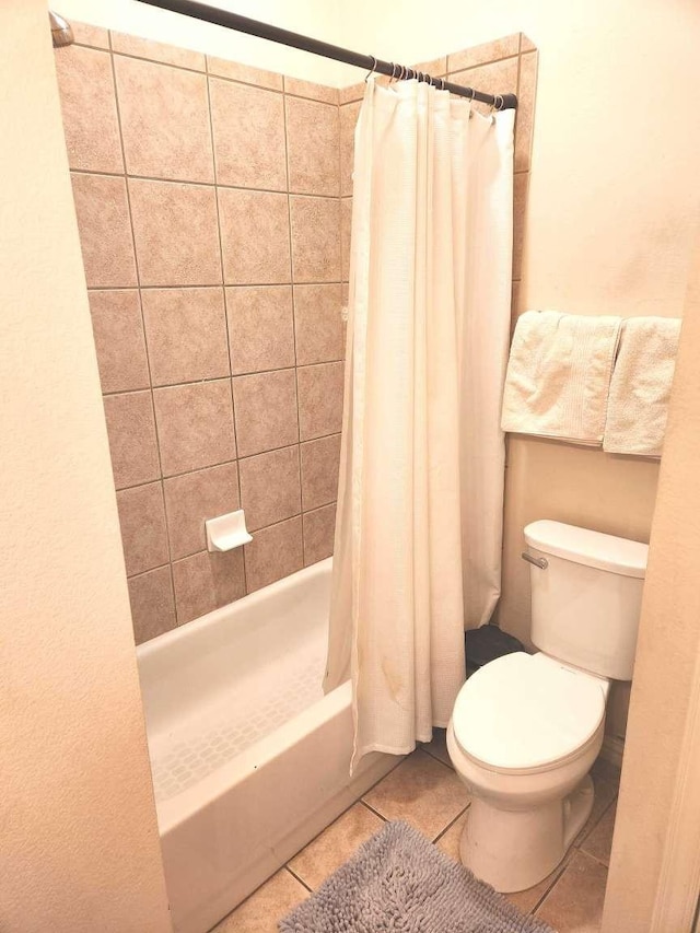 bathroom with tile patterned floors, shower / bathtub combination with curtain, and toilet