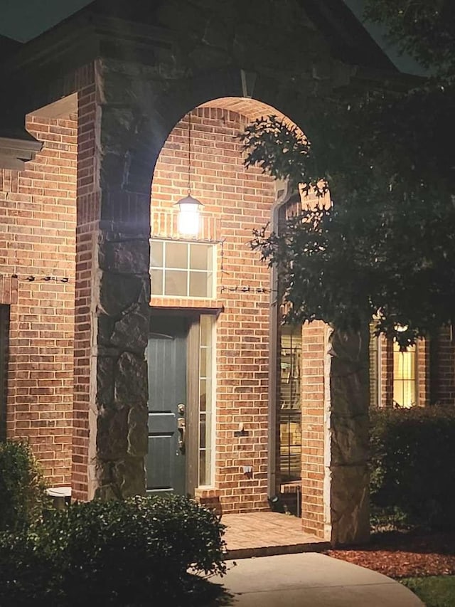 doorway to property with brick siding