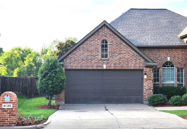 garage featuring concrete driveway and fence