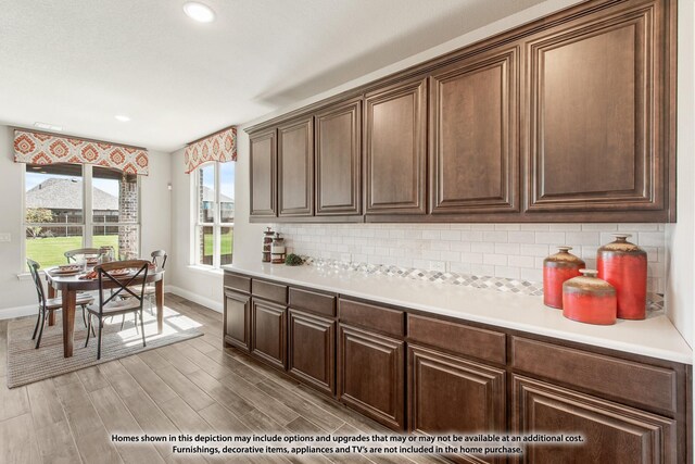 kitchen featuring baseboards, recessed lighting, light countertops, light wood-style floors, and backsplash