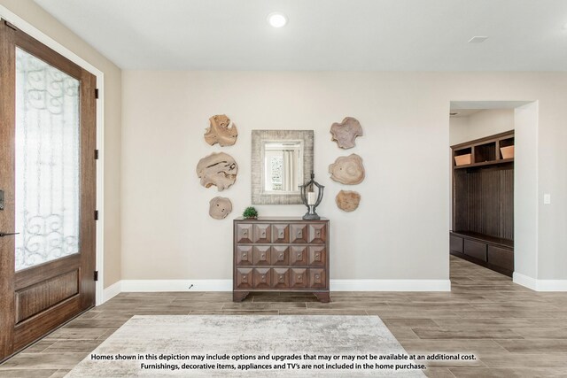 entrance foyer featuring baseboards and wood tiled floor