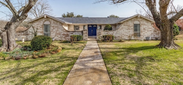 view of front facade with a front yard and brick siding