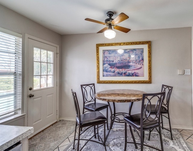 dining room featuring light tile patterned flooring, ceiling fan, and baseboards