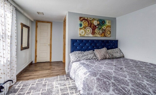 bedroom featuring wood finished floors and visible vents