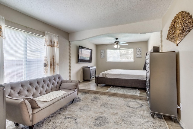 bedroom featuring a textured ceiling, wood finished floors, and a ceiling fan