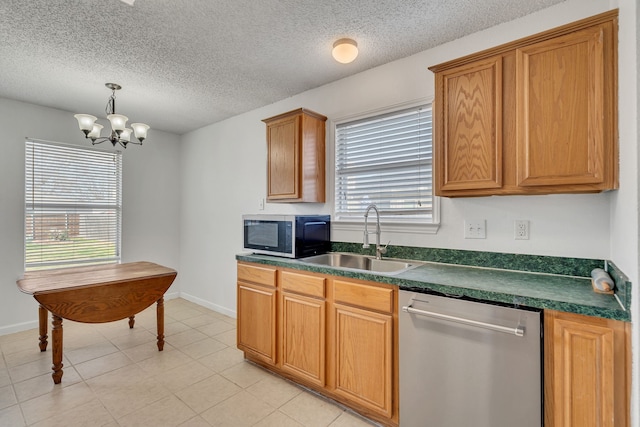 kitchen with baseboards, a sink, stainless steel appliances, dark countertops, and a notable chandelier