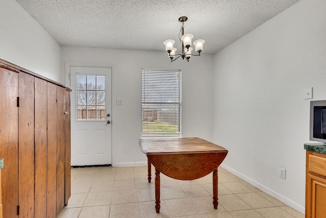 dining room featuring a healthy amount of sunlight, a textured ceiling, and baseboards