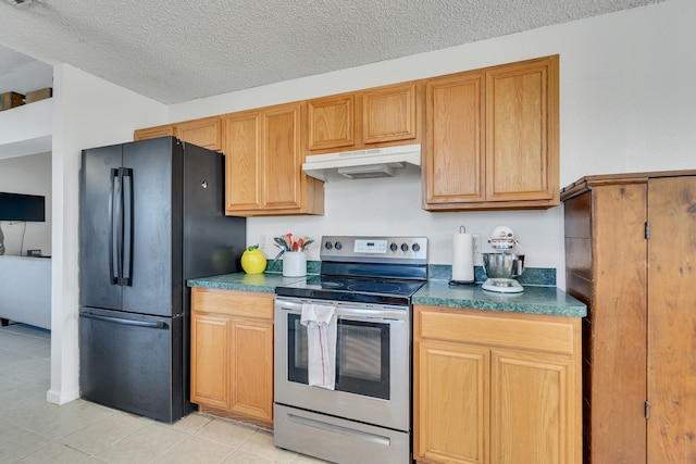 kitchen with freestanding refrigerator, electric stove, under cabinet range hood, a textured ceiling, and dark countertops