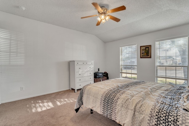 bedroom with baseboards, light colored carpet, lofted ceiling, a textured ceiling, and a ceiling fan