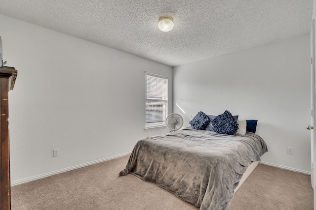 bedroom featuring baseboards, a textured ceiling, and carpet flooring