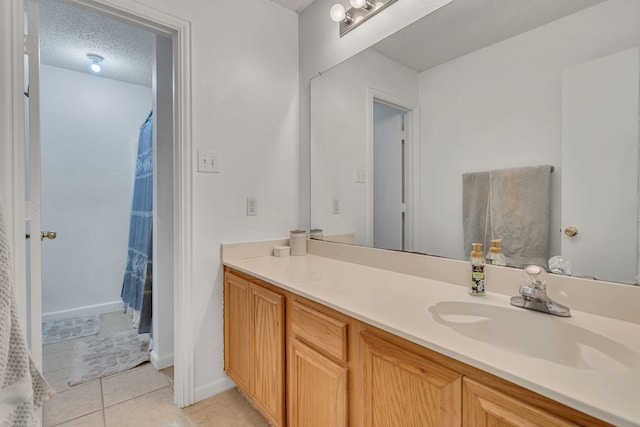 bathroom with baseboards, vanity, a shower with curtain, tile patterned floors, and a textured ceiling