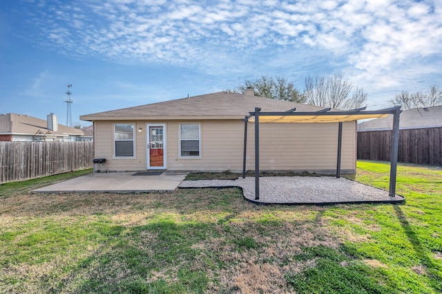 back of property with a yard, a patio area, and a fenced backyard